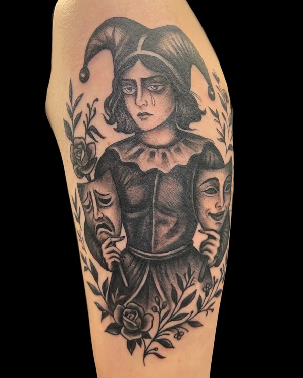 Black and grey jester tattoo with theater masks and roses by Justin Martinez