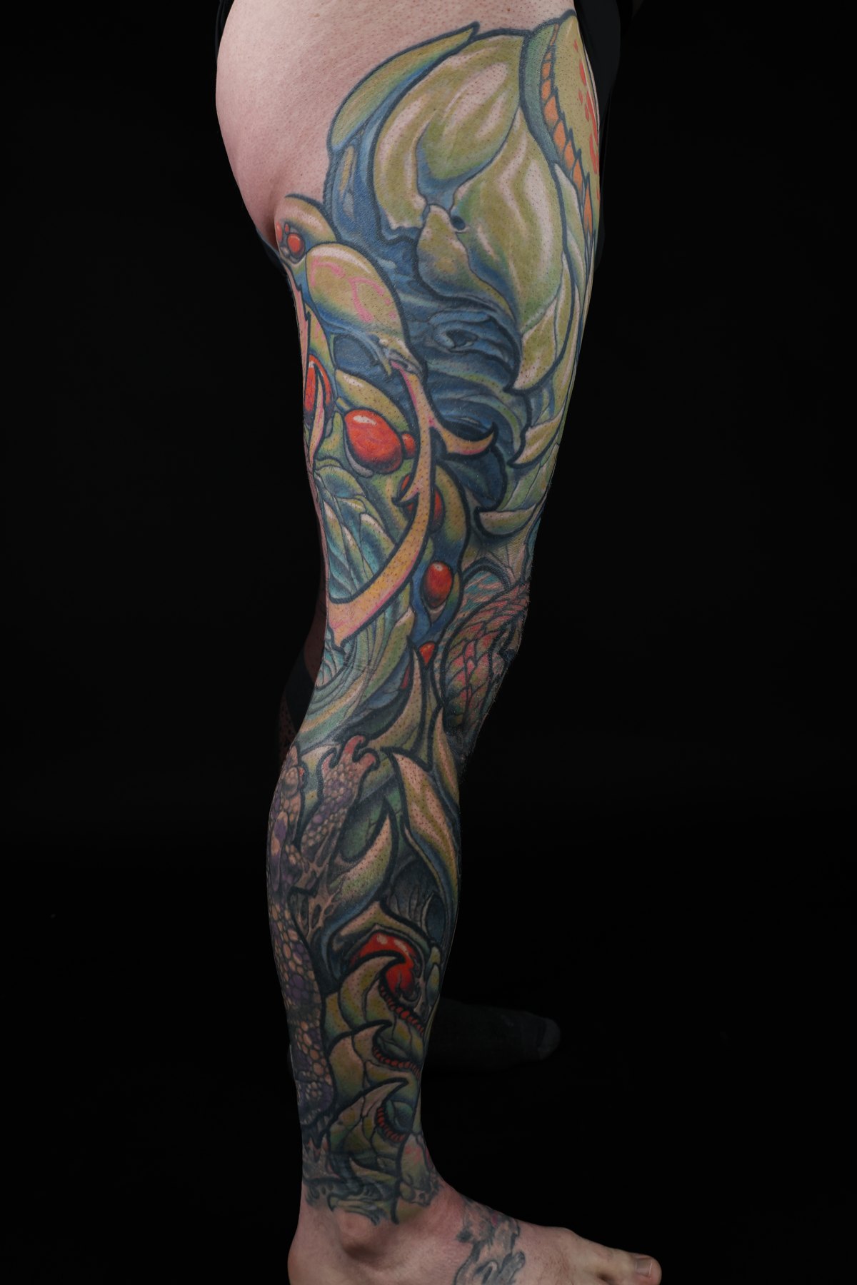 Blue and yellow biomechanical leg tattoo by Josh Standley