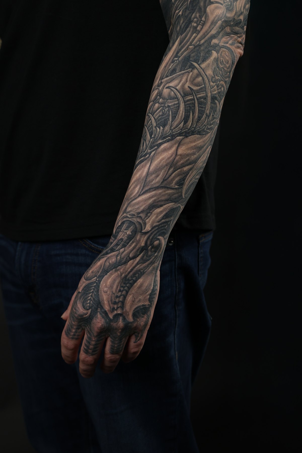 Black and grey biomechanical forearm and hand tattoo by Josh Standley