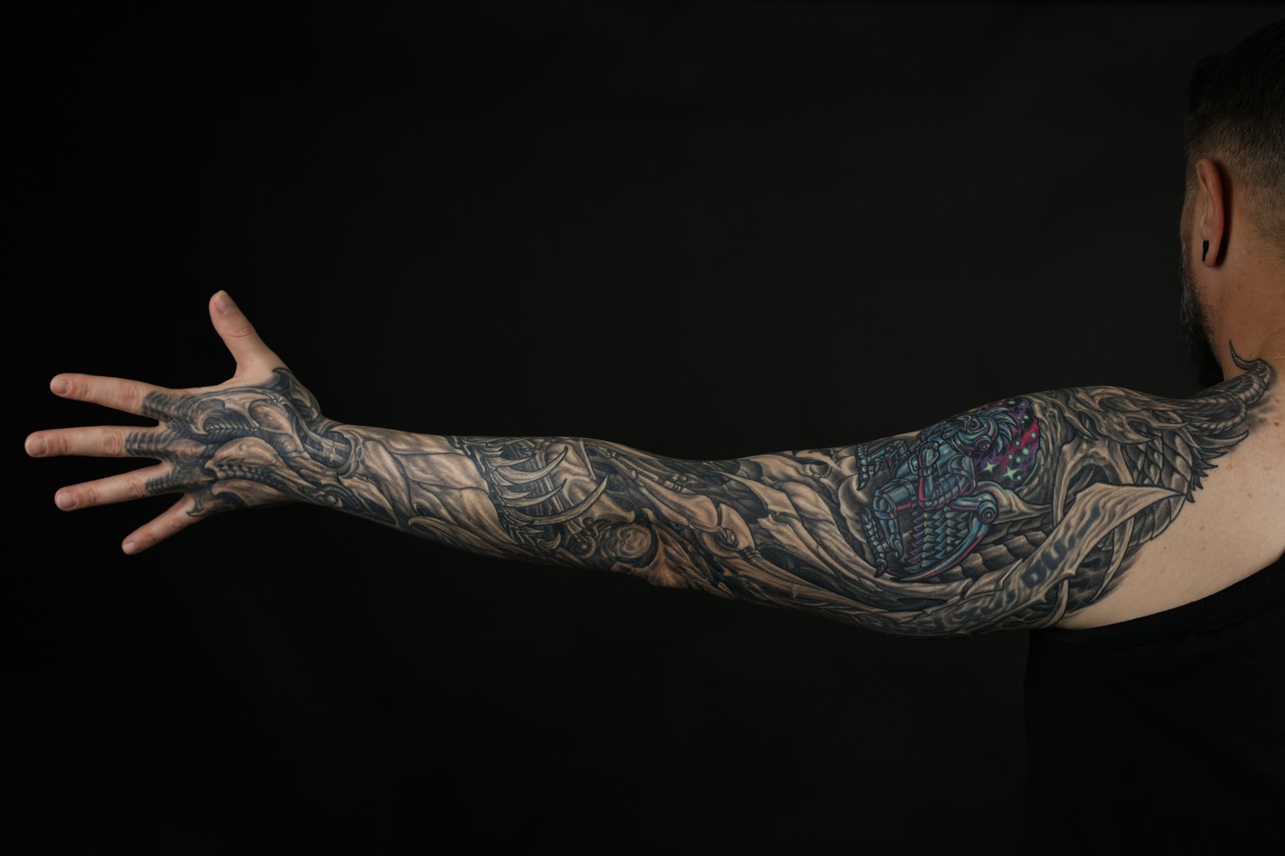 Black and grey biomechanical full-arm tattoo by Josh Standley