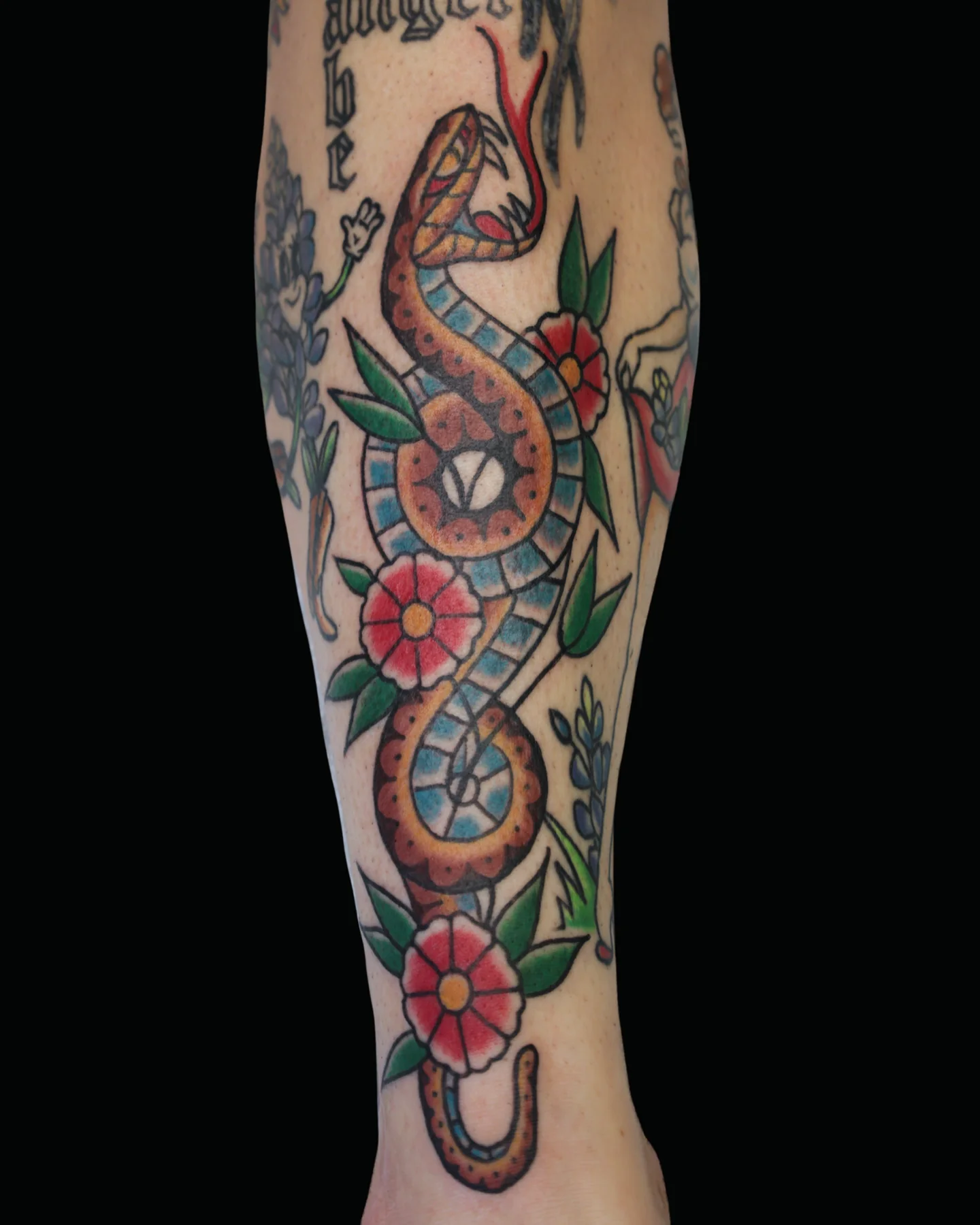 Color snake and woman tattoo with flowers by Nate Haynes