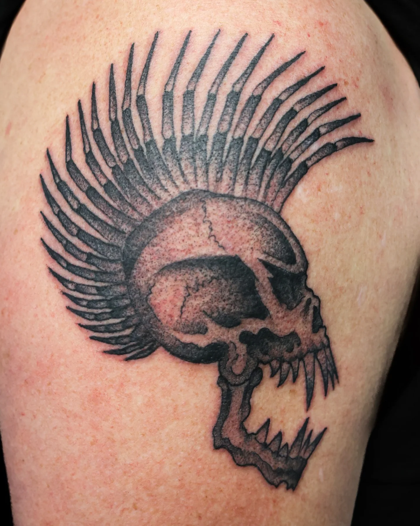 Black and grey skull with feathered headdress tattoo by Nate Haynes