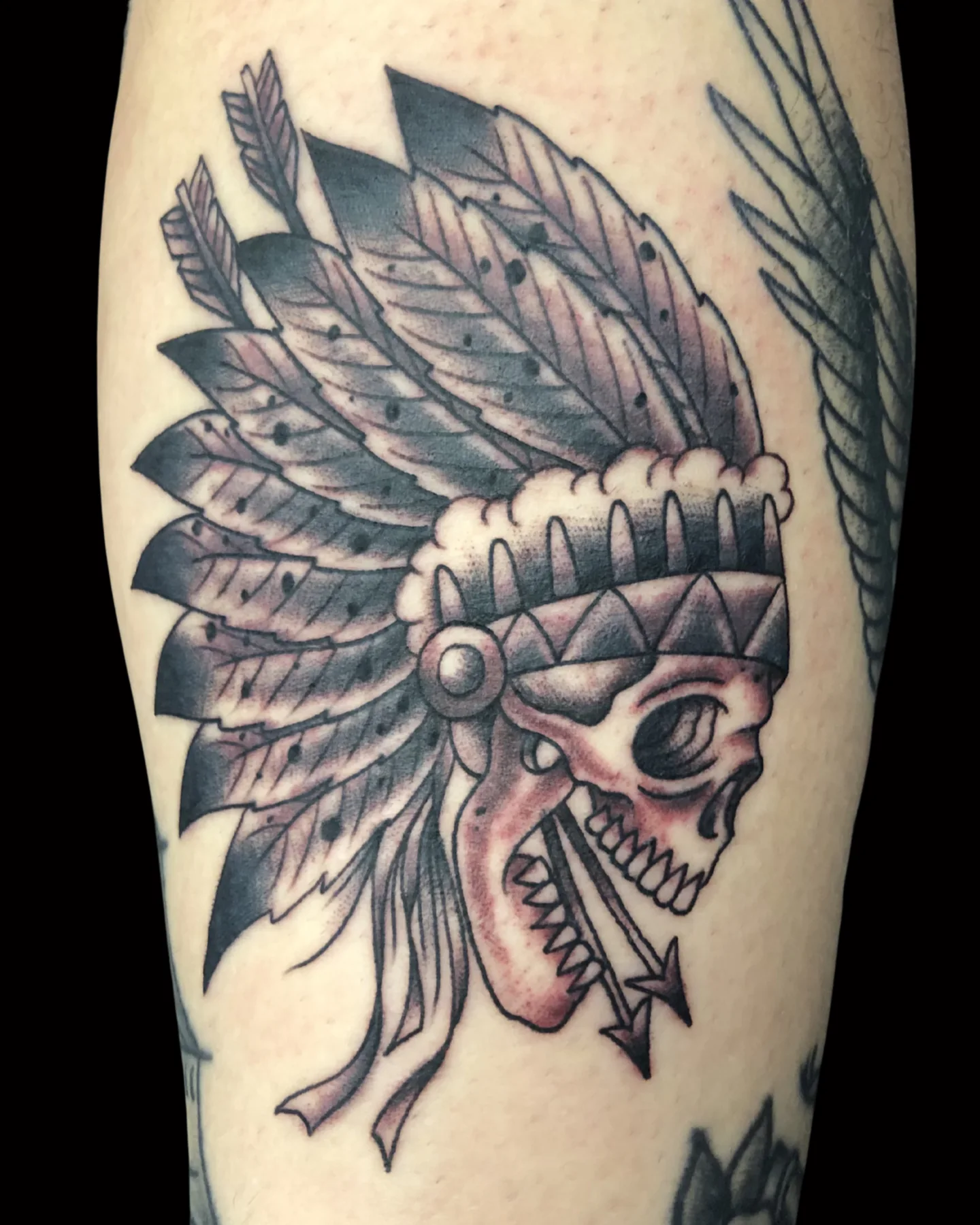 Black and grey skull and feathered headdress tattoo by Chance Ewing
