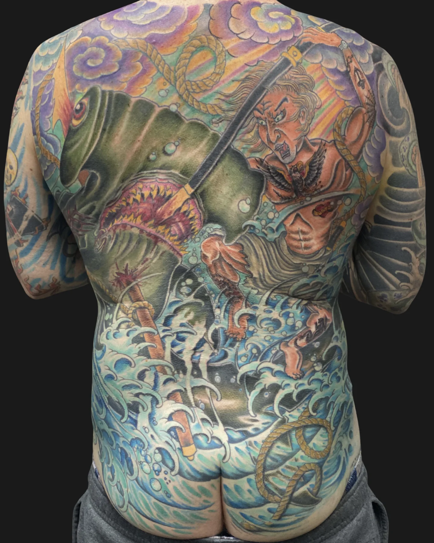 Color full-back tattoo with layered fantasy imagery by Jedidia Reid