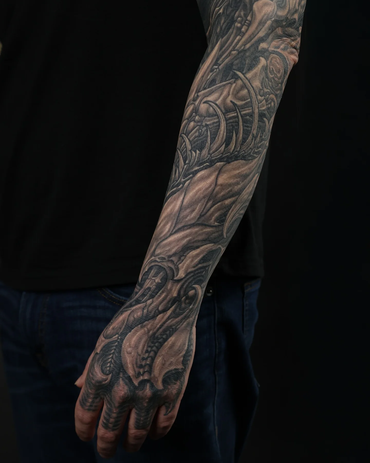 Black and grey biomechanical arm and hand tattoo by Josh Standley