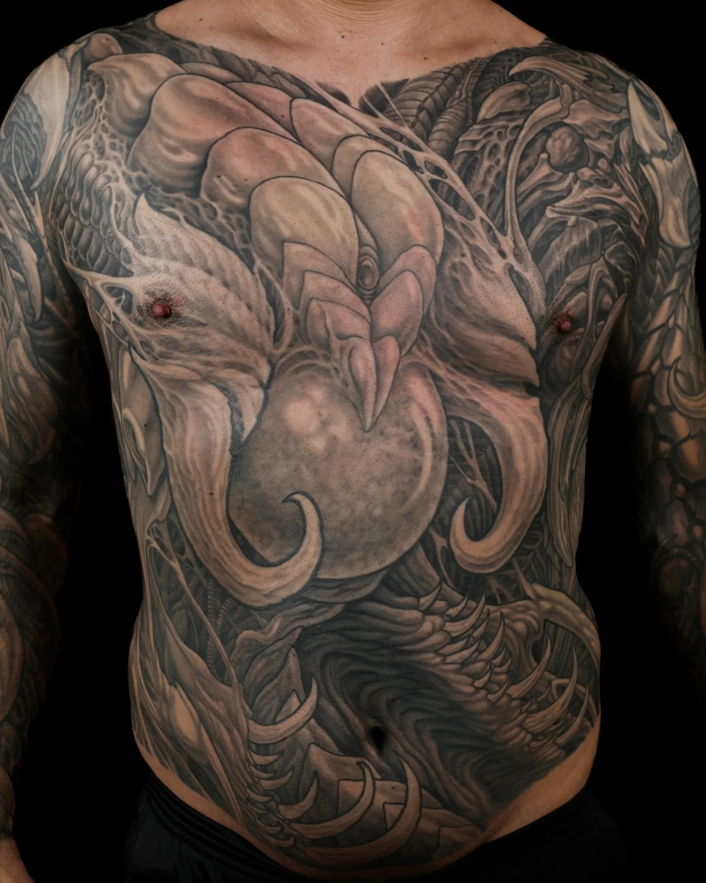 Black and grey biomechanical chest and torso tattoo by Josh Standley
