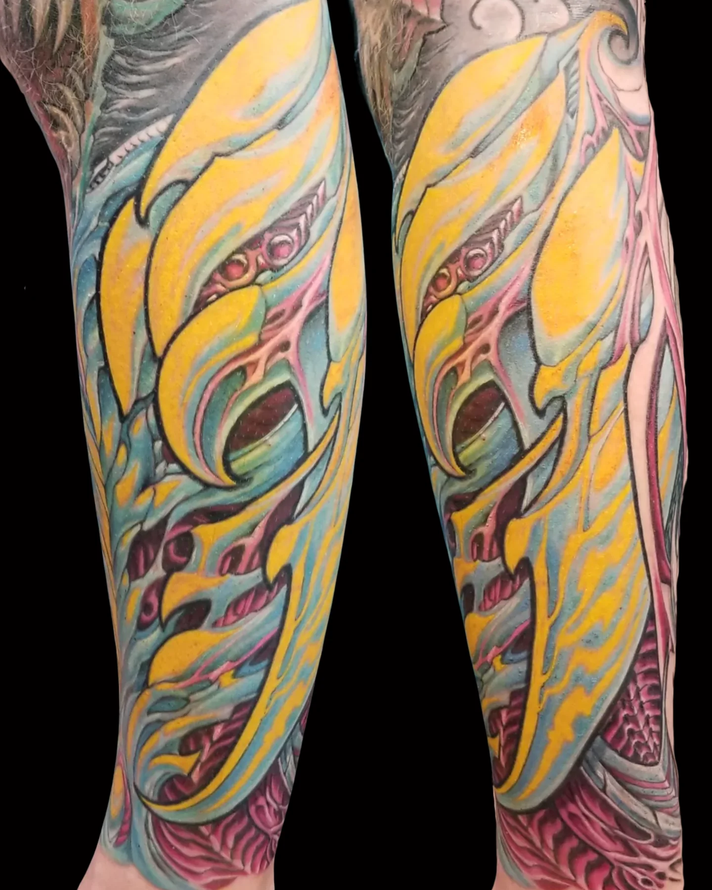 Yellow and blue biomechanical tattoo shown from two angles by Josh Standley