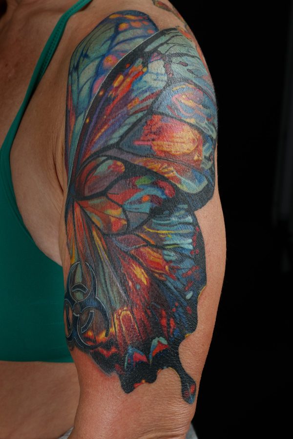 Watercolor butterfly tattoo on the upper arm